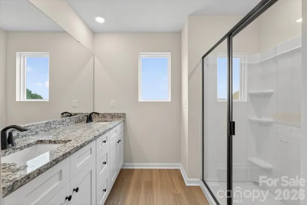a bathroom with a granite countertop sink a mirror and a shower