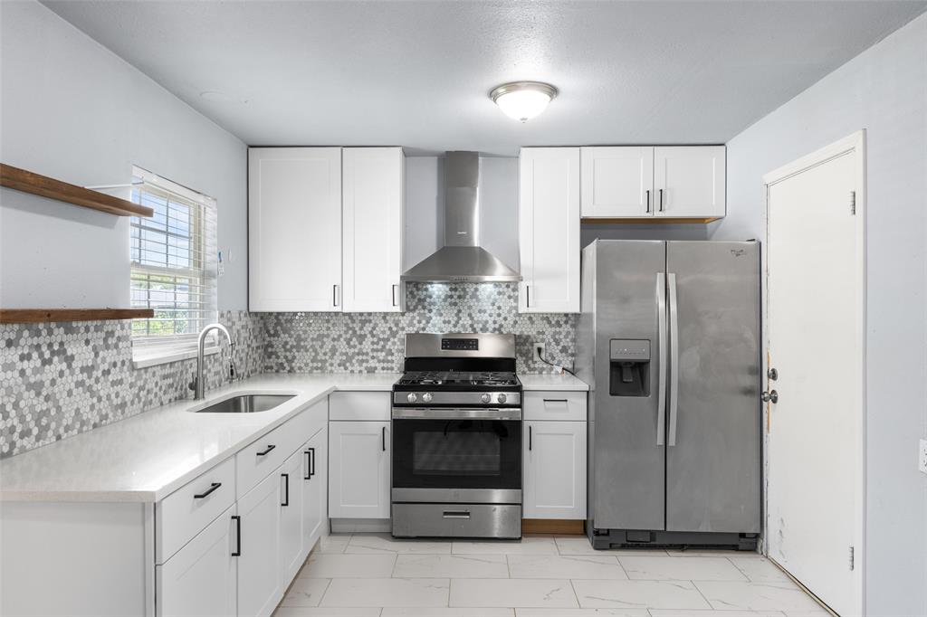 612 East 8th Street Kemp, TX 75143 - Photo 11 of 25 Modern kitchen featuring white shaker cabinetry, stainless steel appliances, a mosaic tile backsplash, white countertops, and light-toned flooring