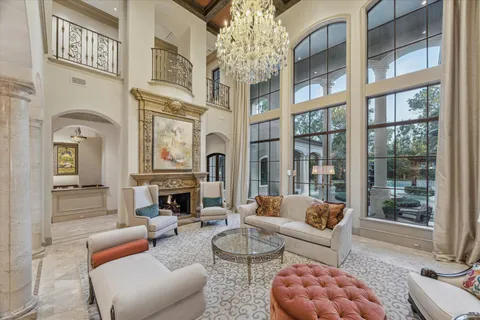 a living room with furniture a fireplace and a chandelier