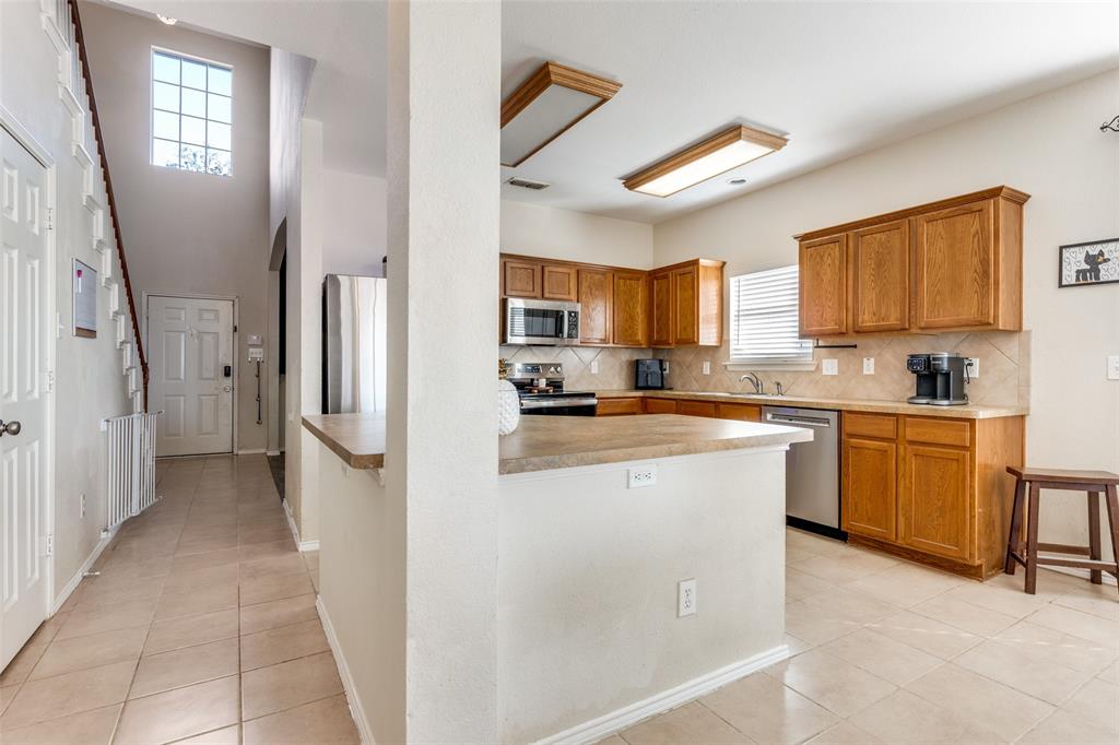 301 Turquoise Drive Fort Worth, TX 76131 - Photo 18 of 33 a kitchen with a refrigerator a stove top oven a sink and dishwasher
