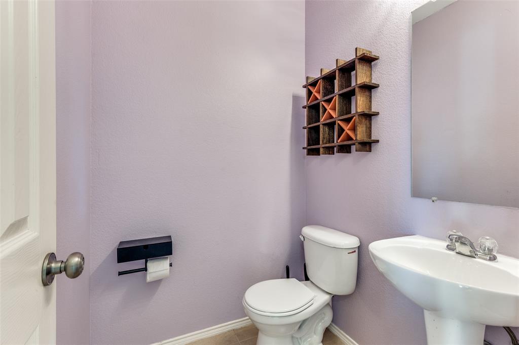 301 Turquoise Drive Fort Worth, TX 76131 - Photo 32 of 33 a white toilet sitting next to a bathroom sink