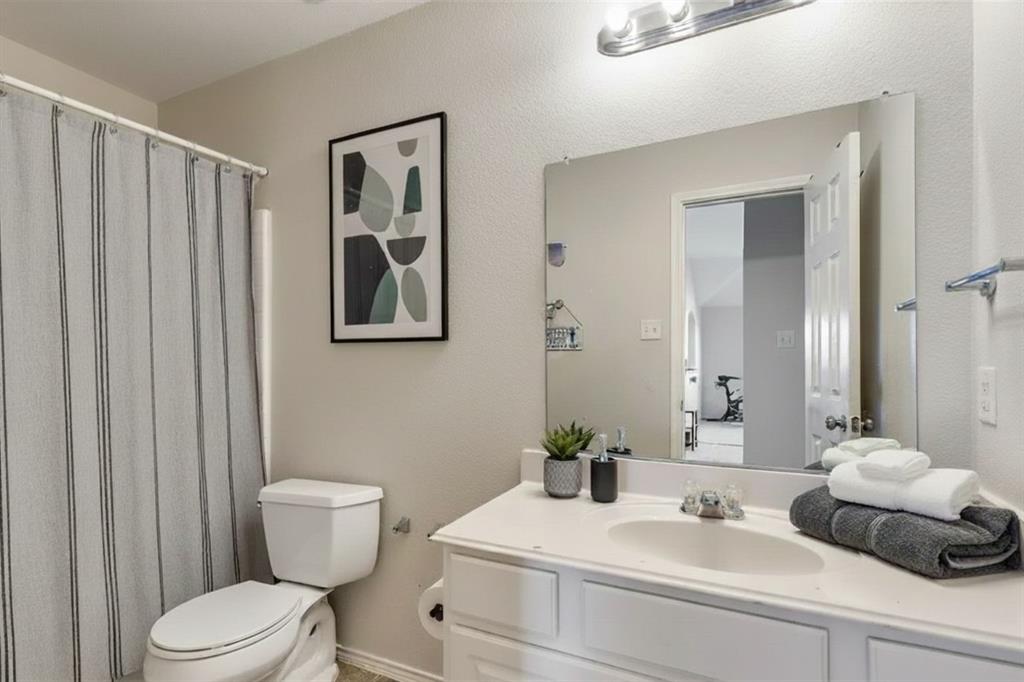 301 Turquoise Drive Fort Worth, TX 76131 - Photo 8 of 33 a bathroom with a toilet a sink and mirror