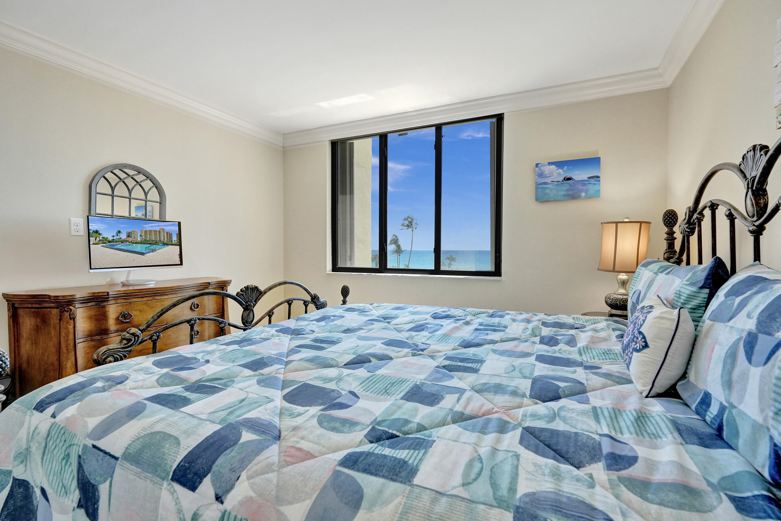 400 Ocean Trail Way, Unit 308 Jupiter, FL 33477 - Photo 38 of 65 a bedroom with a bed a dresser and mirror