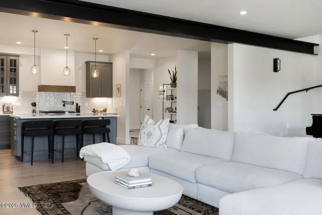 a kitchen with stainless steel appliances granite countertop a sink a stove a refrigerator and island with wooden floor