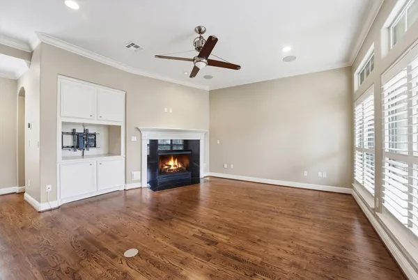 wooden floor fireplace and windows in an empty room