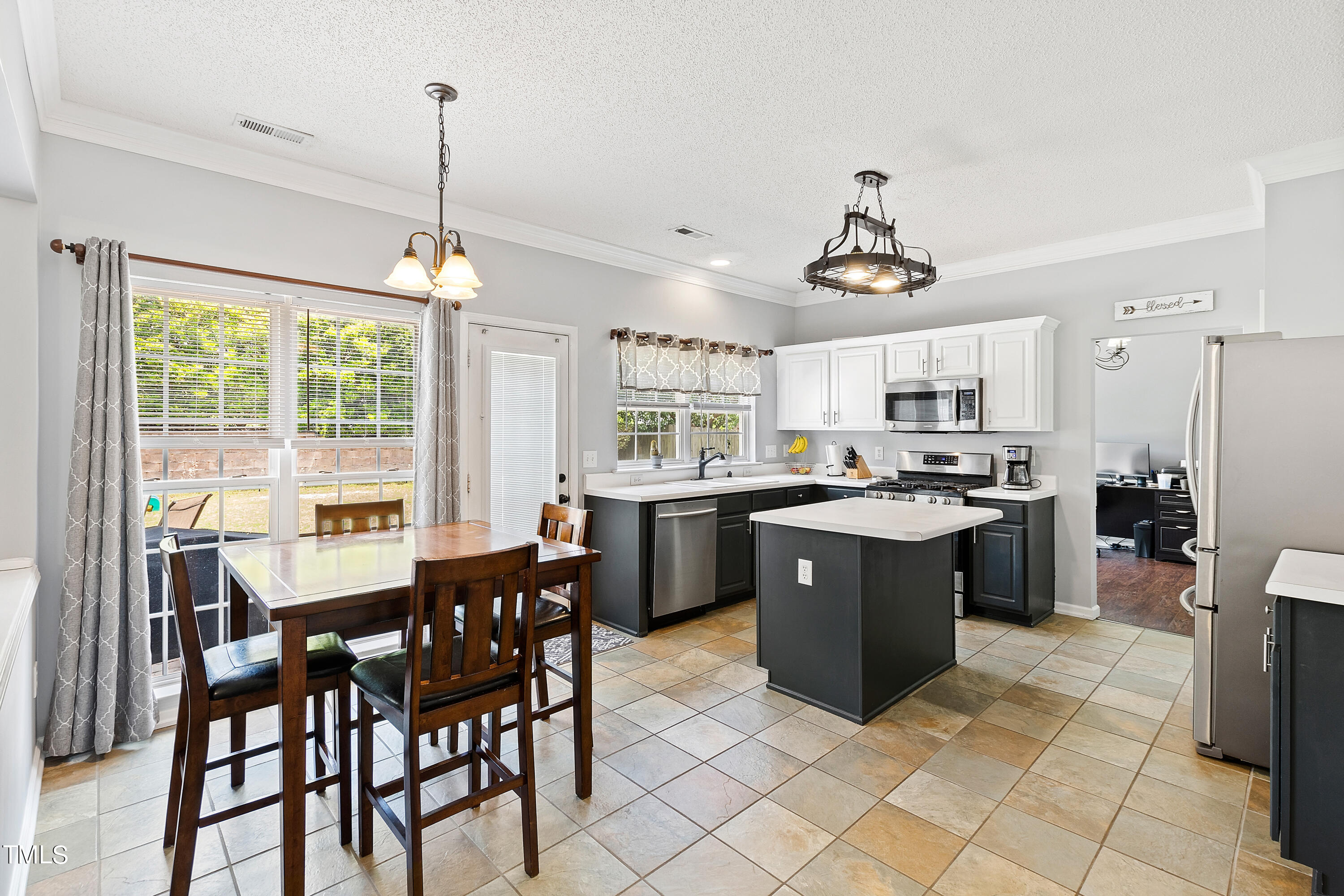 401 New Timber Path Apex, NC 27502 - Photo 11 of 38 a kitchen with a table chairs stove and refrigerator
