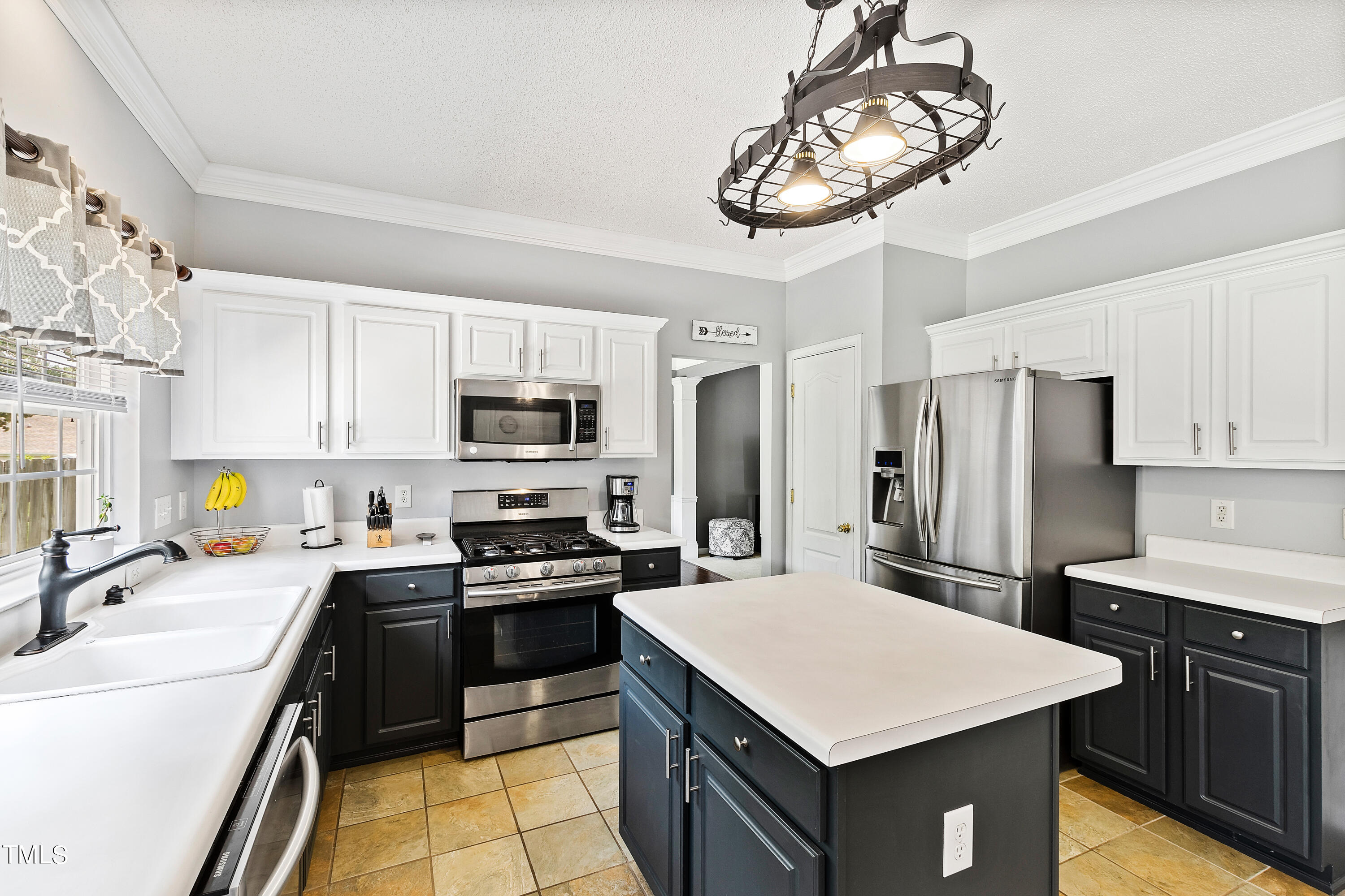 401 New Timber Path Apex, NC 27502 - Photo 13 of 38 a kitchen with stainless steel appliances a sink a stove a refrigerator cabinets and a chandelier