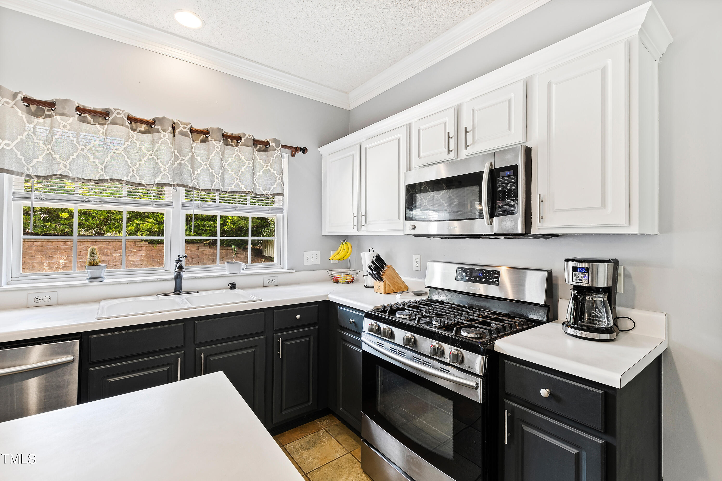 401 New Timber Path Apex, NC 27502 - Photo 14 of 38 a kitchen with stainless steel appliances a sink stove and microwave