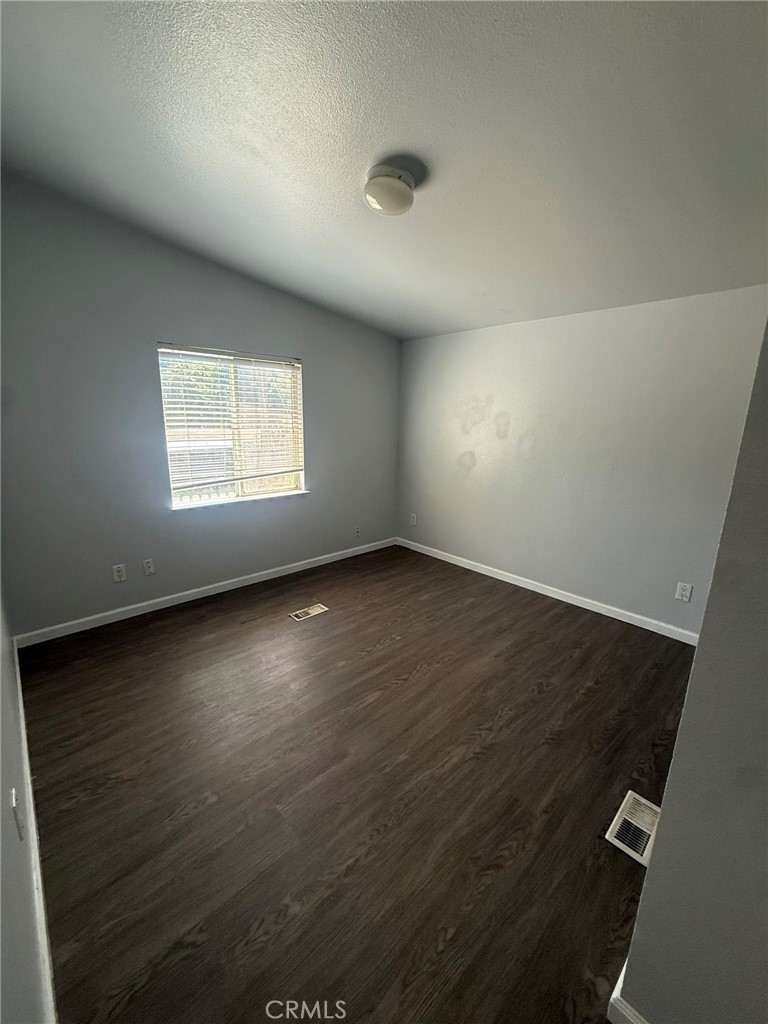 6845 Floyd Way Nice, CA 95464 - Photo 19 of 59 an empty room with wooden floor and windows
