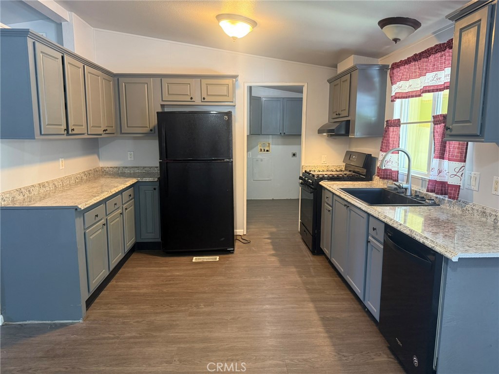 6845 Floyd Way Nice, CA 95464 - Photo 6 of 59 a kitchen with granite countertop a refrigerator a sink and wooden cabinets