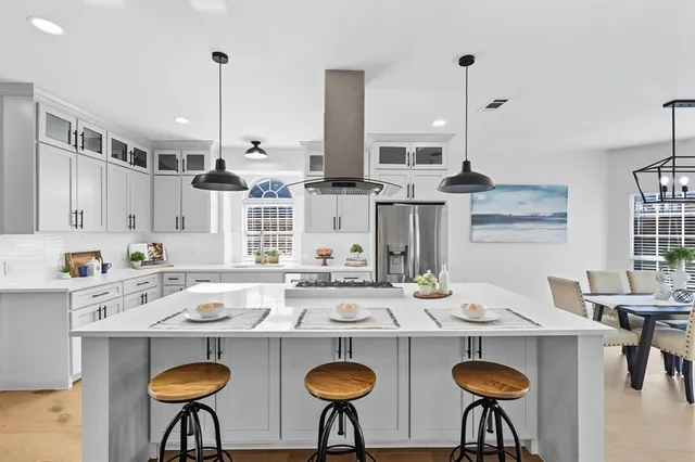 a kitchen with a table chairs stove and kitchen island