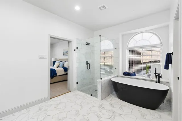 a spacious bedroom with a bed and a potted plant