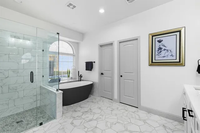 a spacious bathroom with a tub sink and mirror