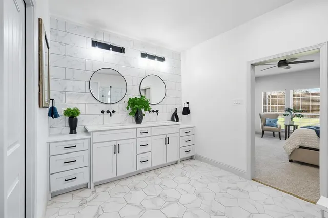 a spacious bathroom with a double vanity sink mirror and bathtub