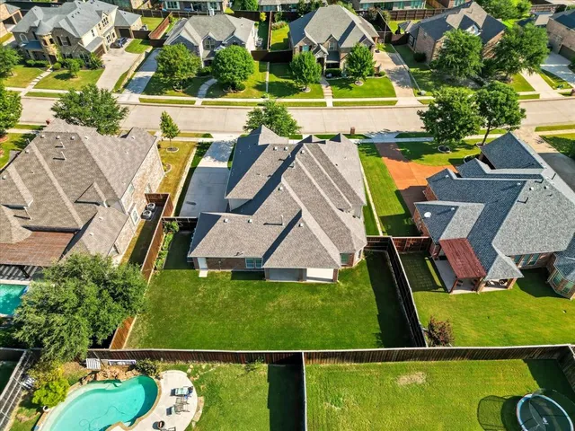 a view of a house next to a big yard and large trees