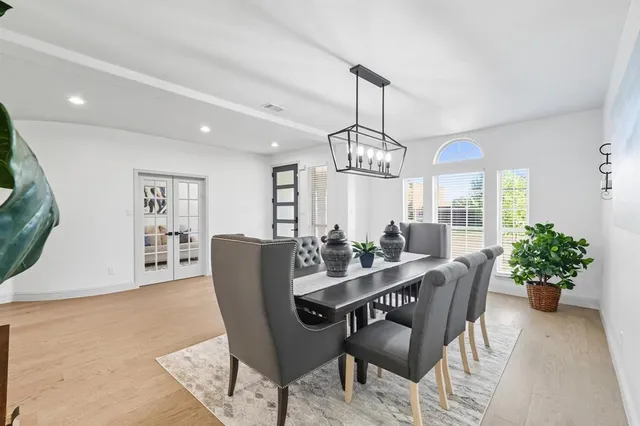 a view of a dining room with furniture a livingroom and chandelier