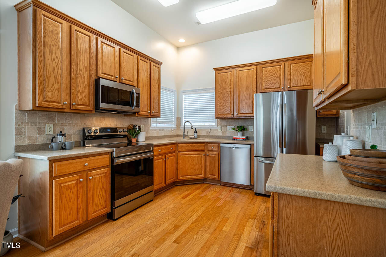 1314 Mallory Lane Durham, NC 27713 - Photo 18 of 47 a kitchen with granite countertop wooden cabinets a stove top oven and stainless steel appliances