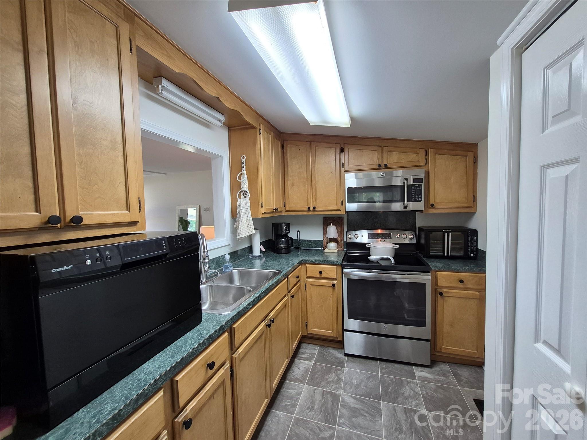 4438 Reepsville Road Vale, NC 28168 - Photo 18 of 32 a kitchen with stainless steel appliances granite countertop a stove a sink and a microwave