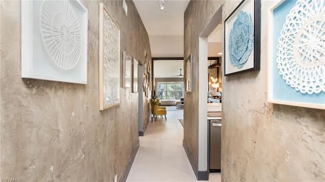 a view of hallway with livingroom and wooden floor