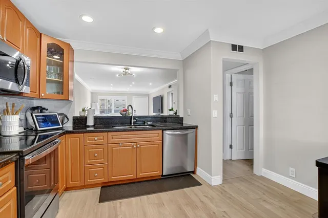 a kitchen with stainless steel appliances granite countertop a sink and cabinets
