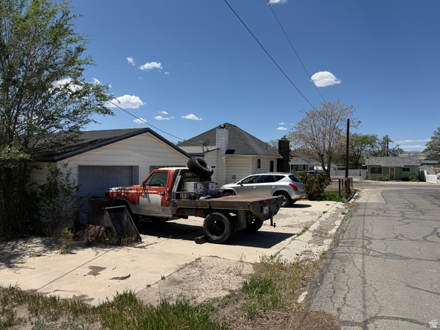 196 North 5th West Price, UT 84501 - Photo 25 of 27 White siding garage with a gabled roof and attached concrete driveway