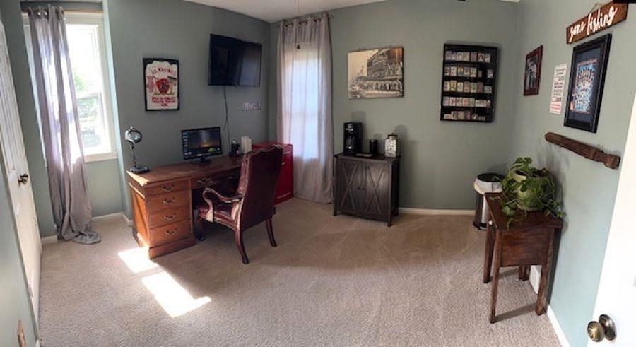 1897 Corbin Road Germantown, TN 38139 - Photo 13 of 22 Carpeted room featuring a built-in wall-mounted television, two windows with drapery, and a functional built-in wall rack