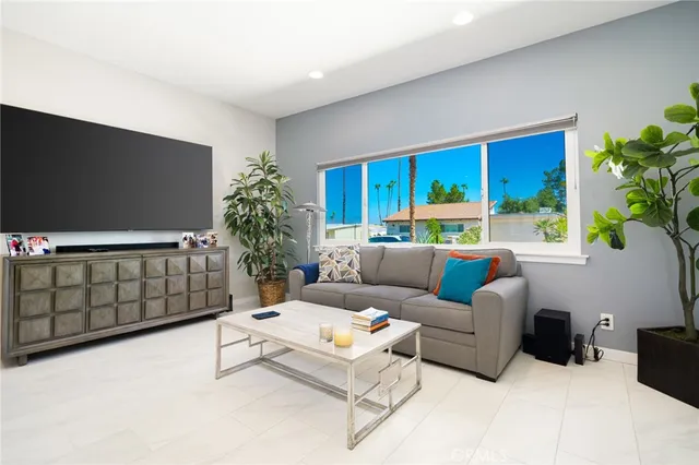 a living room with furniture a chandelier and a dining table with wooden floor