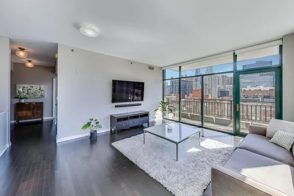 a living room with furniture a flat screen tv and a floor to ceiling window