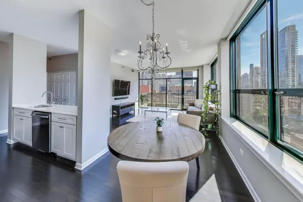 a dining room with chandelier a wooden table and chairs