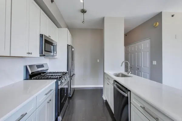 a kitchen with stainless steel appliances a sink stove and cabinets