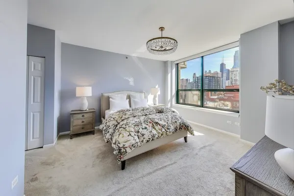 a bedroom with a bed and a large window