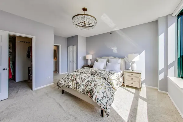 a bedroom with a bed and a chandelier