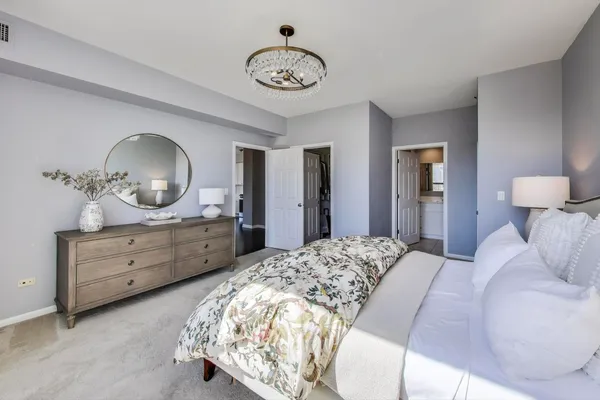 a bedroom with a bed and a chandelier