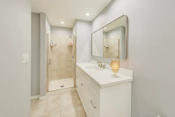 a bathroom with a sink a mirror and a shower