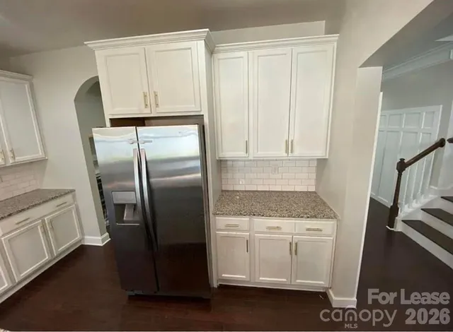 a kitchen with a refrigerator stove and white cabinets