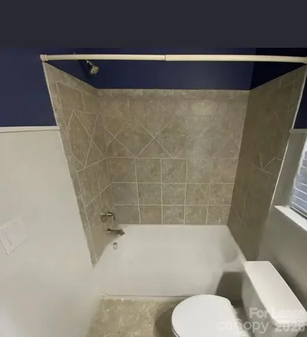 a bathroom with a toilet and bathtub