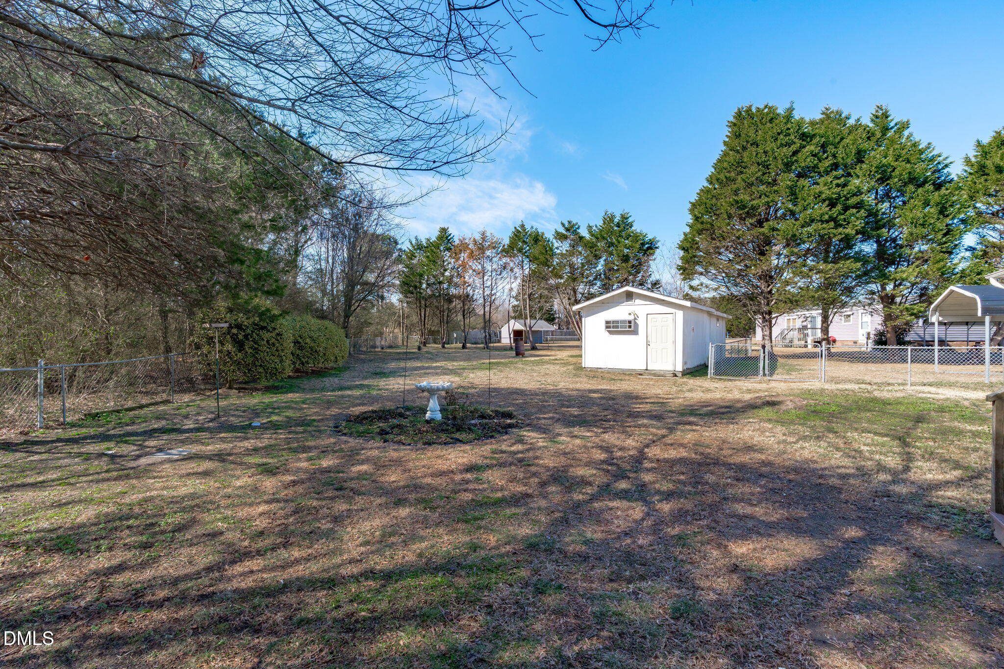 7900 Barbour Store Road Willow Spring, NC 27592 - Photo 29 of 38 a backyard of a house with large trees and outdoor seating