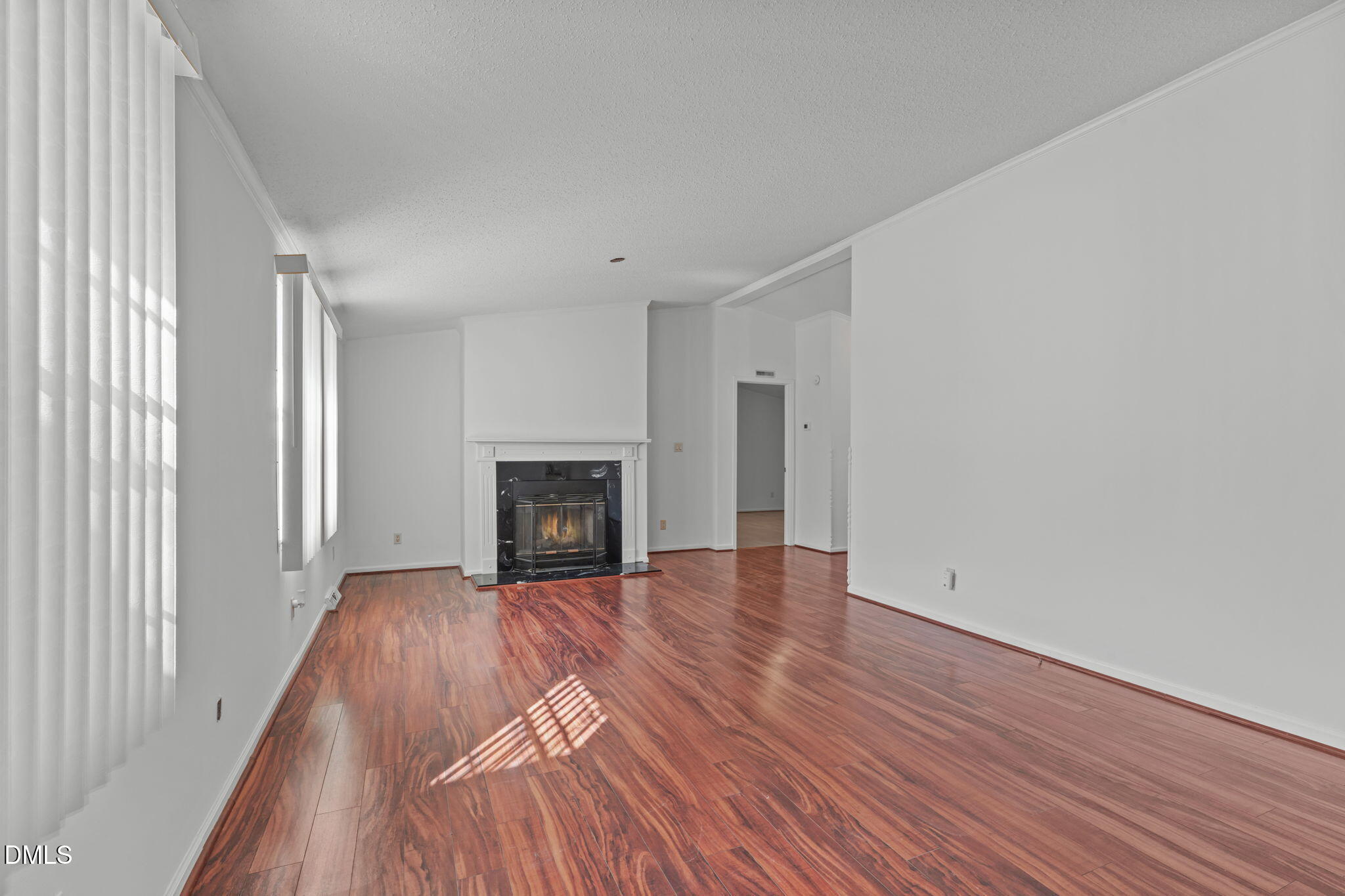 7900 Barbour Store Road Willow Spring, NC 27592 - Photo 5 of 38 a view of an empty room with wooden floor fireplace and a window