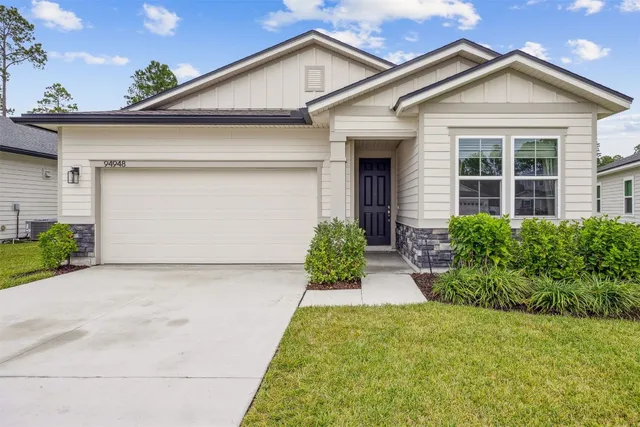 a view of a white house next to a yard
