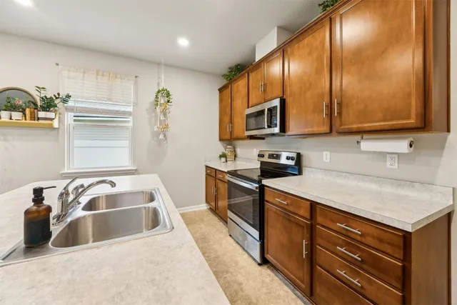 a view of a refrigerator in kitchen and wooden cabinets