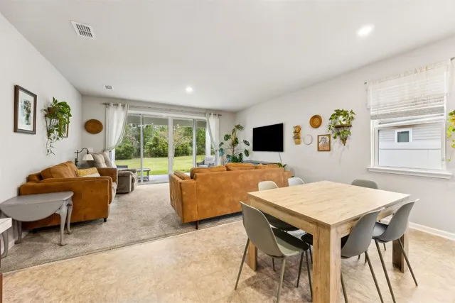 a kitchen with granite countertop kitchen island stainless steel appliances a stove a sink a refrigerator cabinets and a dining table