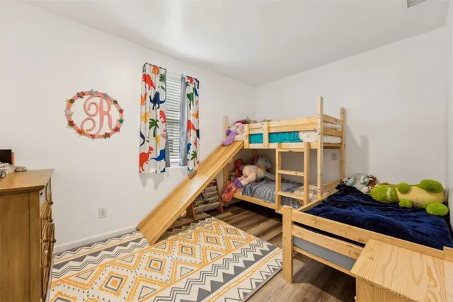 a view of a livingroom with wooden floor and a bathroom