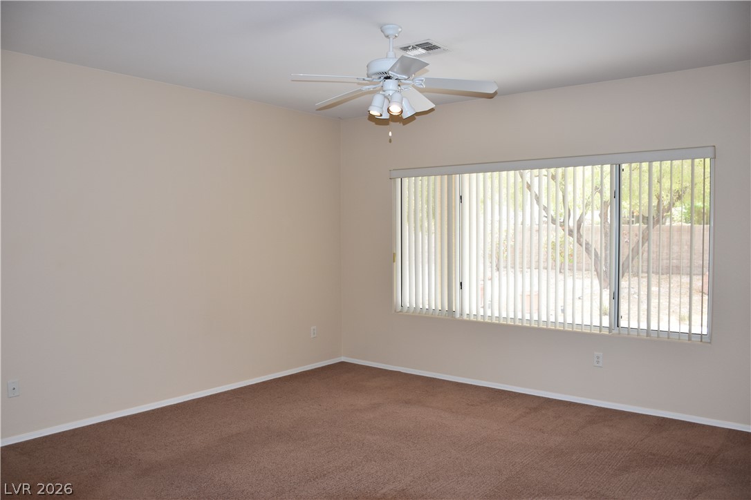 1680 Fieldbrook Street Henderson, NV 89052 - Photo 9 of 32 A wide window illuminates this bedroom featuring plush carpeting and clean neutral walls.