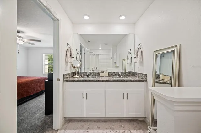 a bathroom with a granite countertop sink a mirror and a vanity