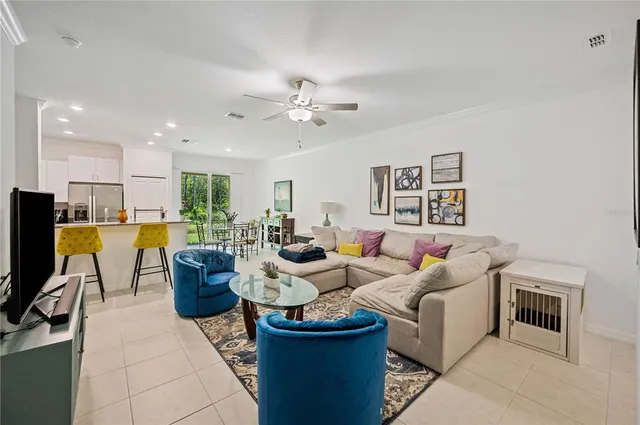 a living room with furniture a flat screen tv and kitchen view