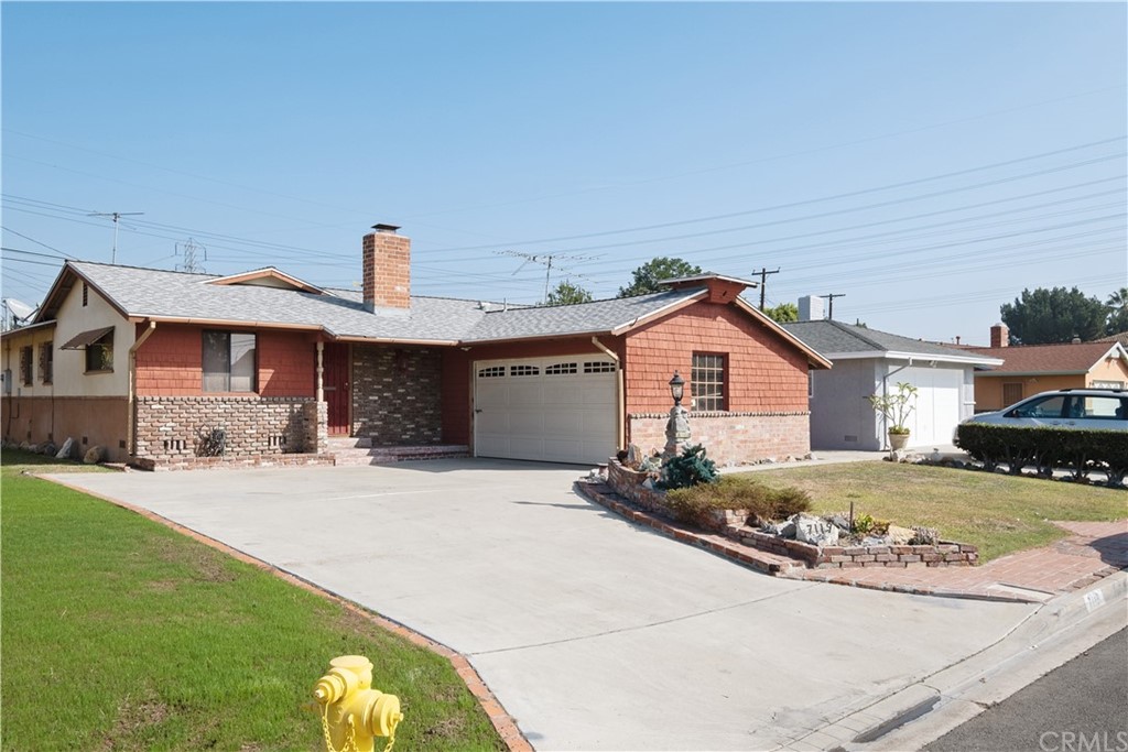 7119 Cortland Avenue Paramount, CA 90723 - Photo 2 of 30 a front view of a house with a yard and garage
