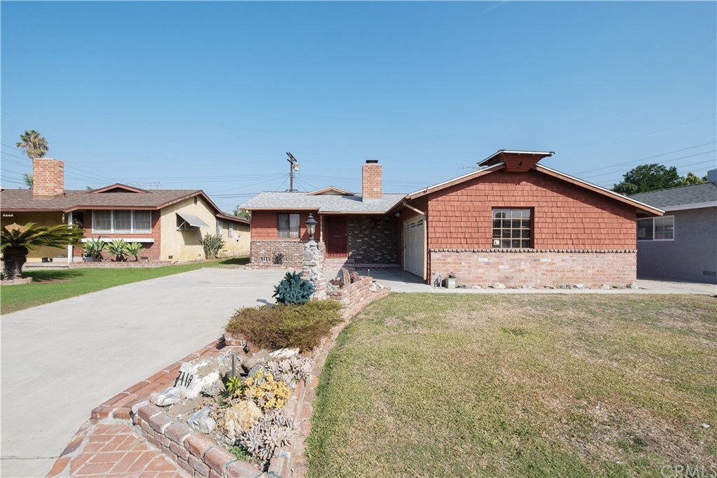 7119 Cortland Avenue Paramount, CA 90723 - Photo 3 of 30 a front view of a house with a yard and garage