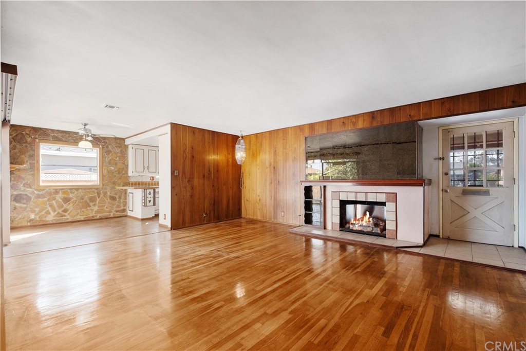 7119 Cortland Avenue Paramount, CA 90723 - Photo 7 of 30 a view of a big room with wooden floor fire place and windows