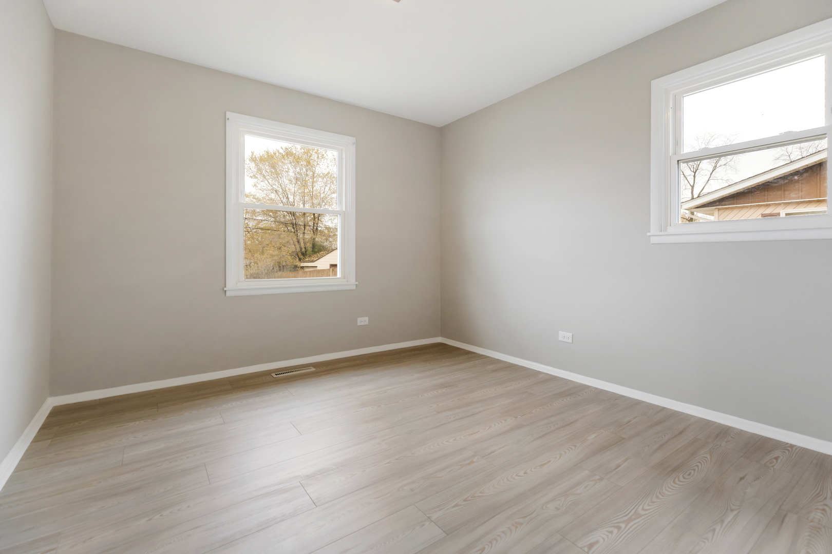 6971 Hanover Street Hanover Park, IL 60133 - Photo 10 of 20 an empty room with wooden floor and windows