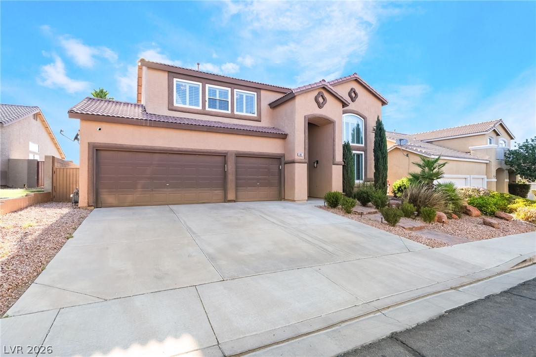 261 Timber Hollow Street Henderson, NV 89012 - Photo 4 of 51 A well-maintained stucco home with a double garage and landscaped front yard awaits.